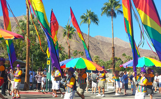 Pride parade with marchers holding rainbow flags